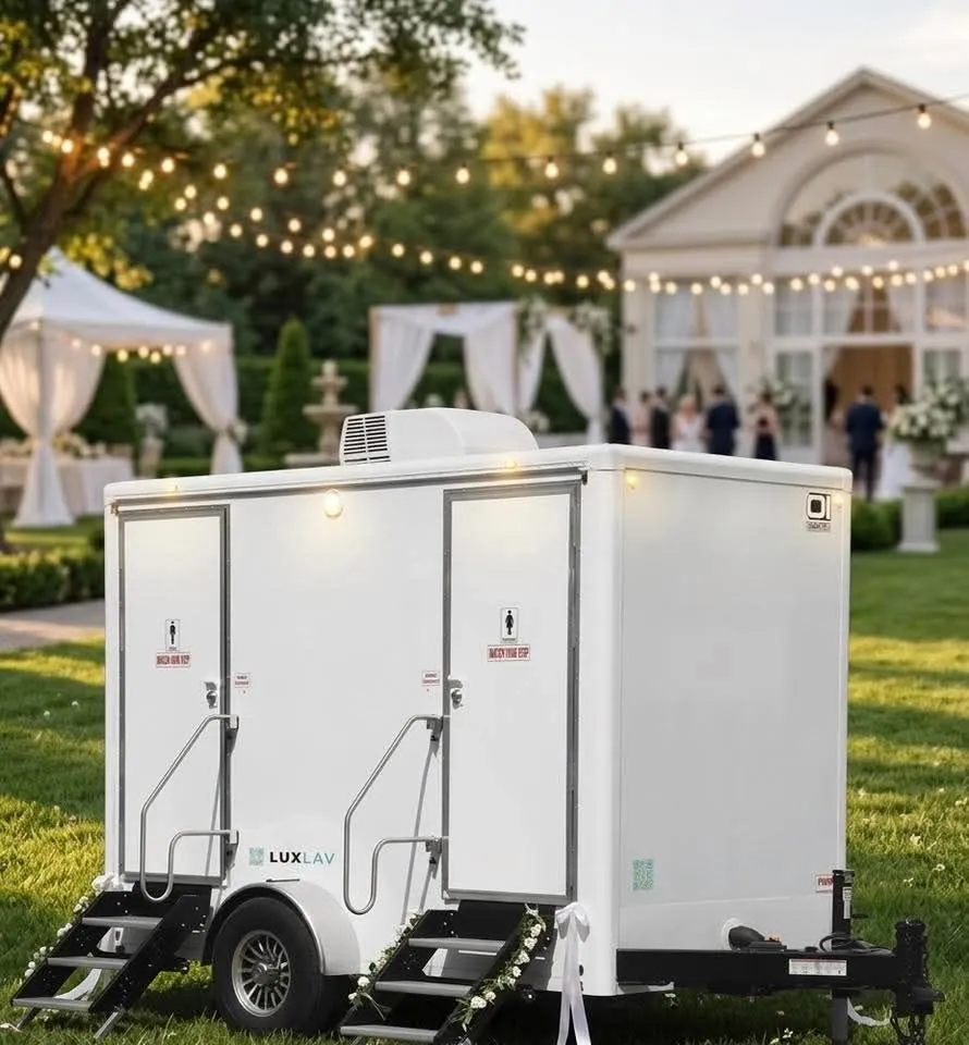 Luxury restroom trailer set up on the lawn at an elegant outdoor wedding reception with string lights